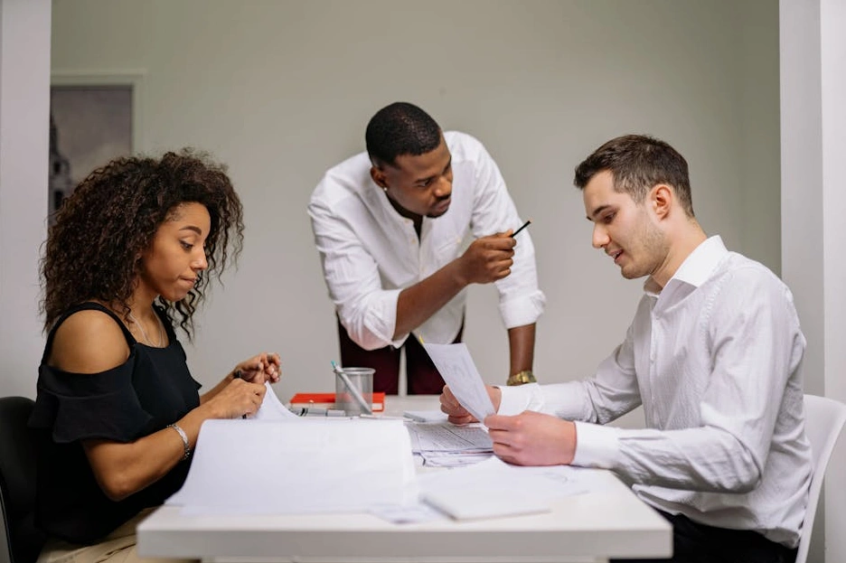 Zróżnicowany zespół współpracujący przy tablicy z wykresami finansowymi.